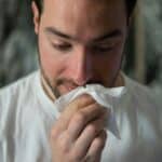 a man wiping his nose