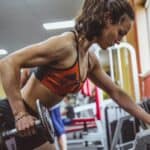 a woman lifting weight in a gym