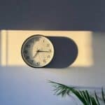 a clock in a room with a sun shining on it