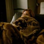 a girl under a blanket on couch