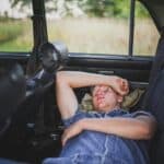 man having motion sickness in car