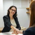two woman shaking hands talking