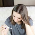 a woman checking a thermometer